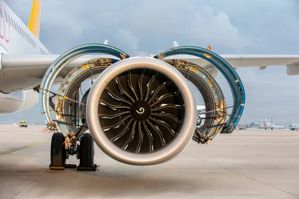 Airliner engine on the apron with its nacelle and thrust reverser halves opened for maintenance